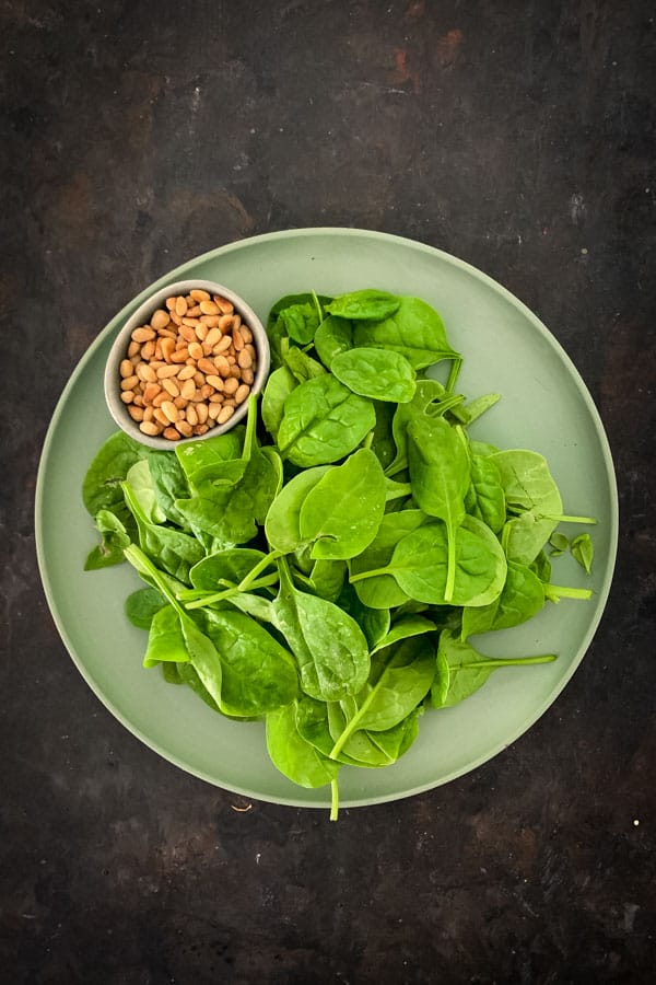 Toasted pine nuts and raw bay spinach