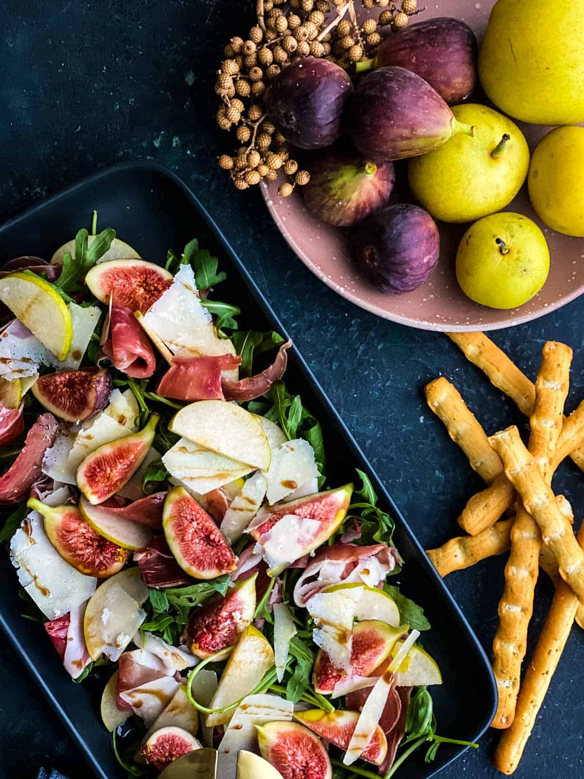 Fig and Prosciutto Salad with Nashi Pear on a rectangular platter served with breadsticks