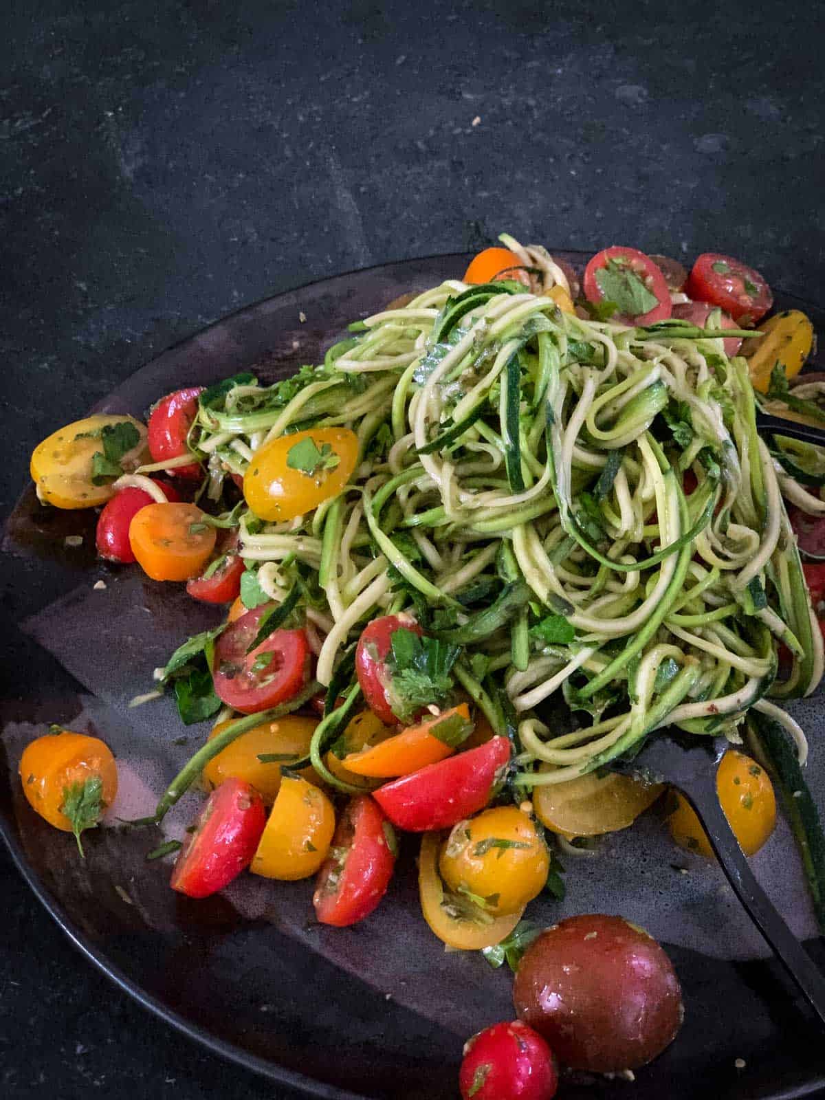 Vegan Zucchini Noodle Salad with Pesto on a dark plate