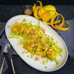 Spaghetti Squash Salad with Asparagus on an oval platter served with roasted sesame dressing in a jar