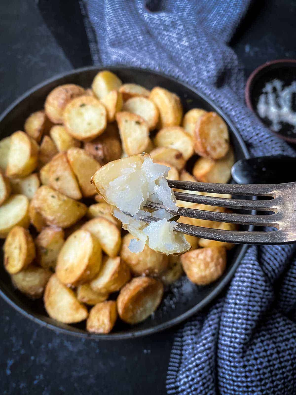 Spoon picking up a serve of Air Fryer Potatoes with Truffle Salt