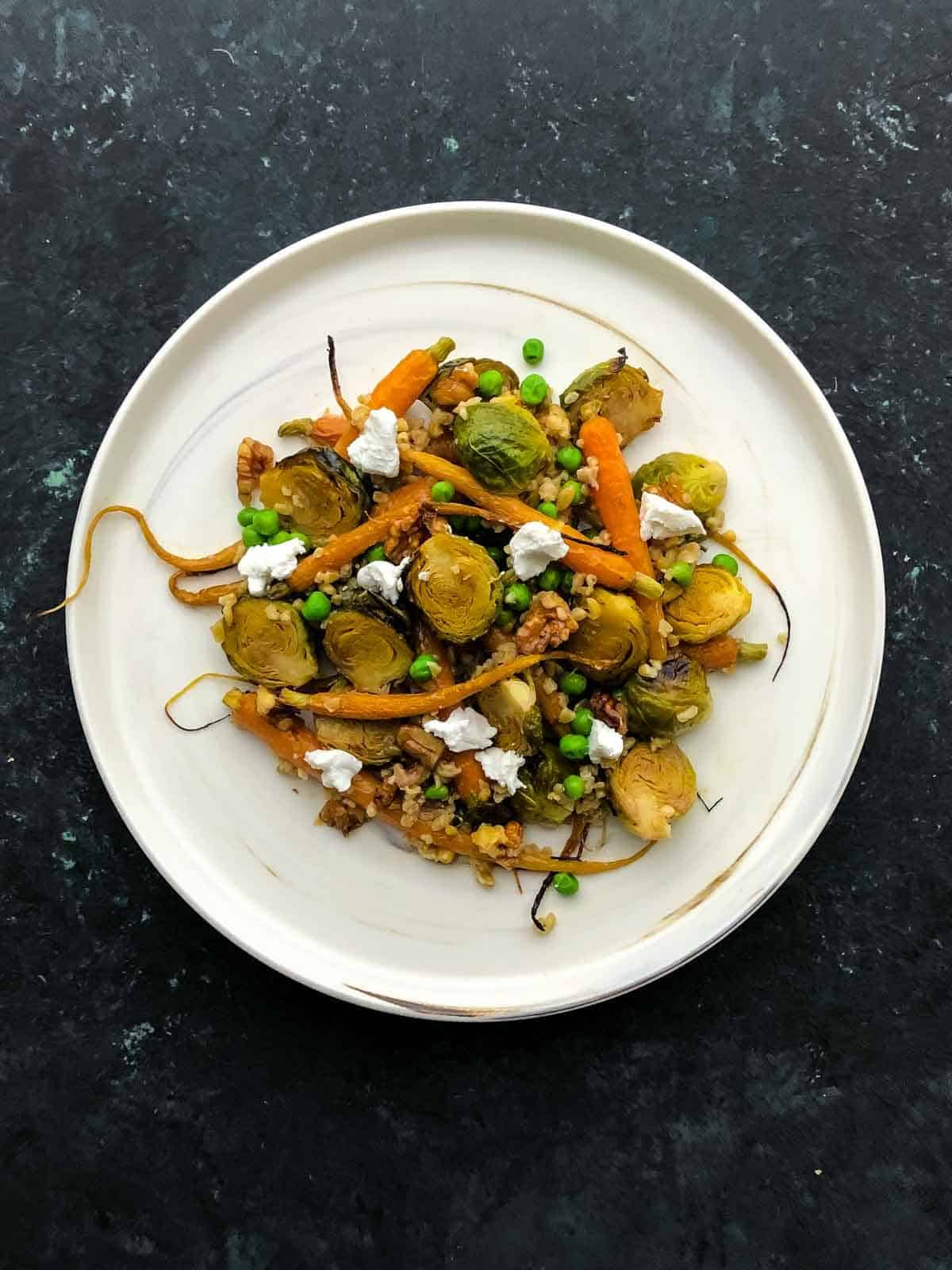 Roasted Brussels Sprouts And Carrots on a marbled white plate