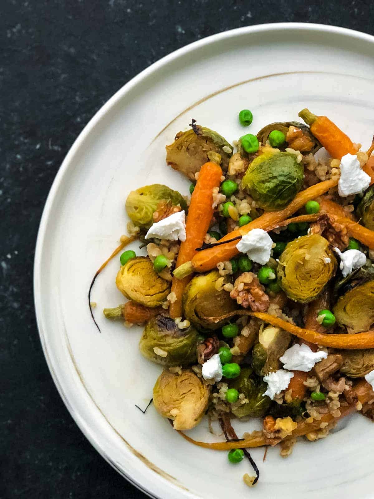 Roasted Brussels Sprouts And Carrots on a marbled white plate