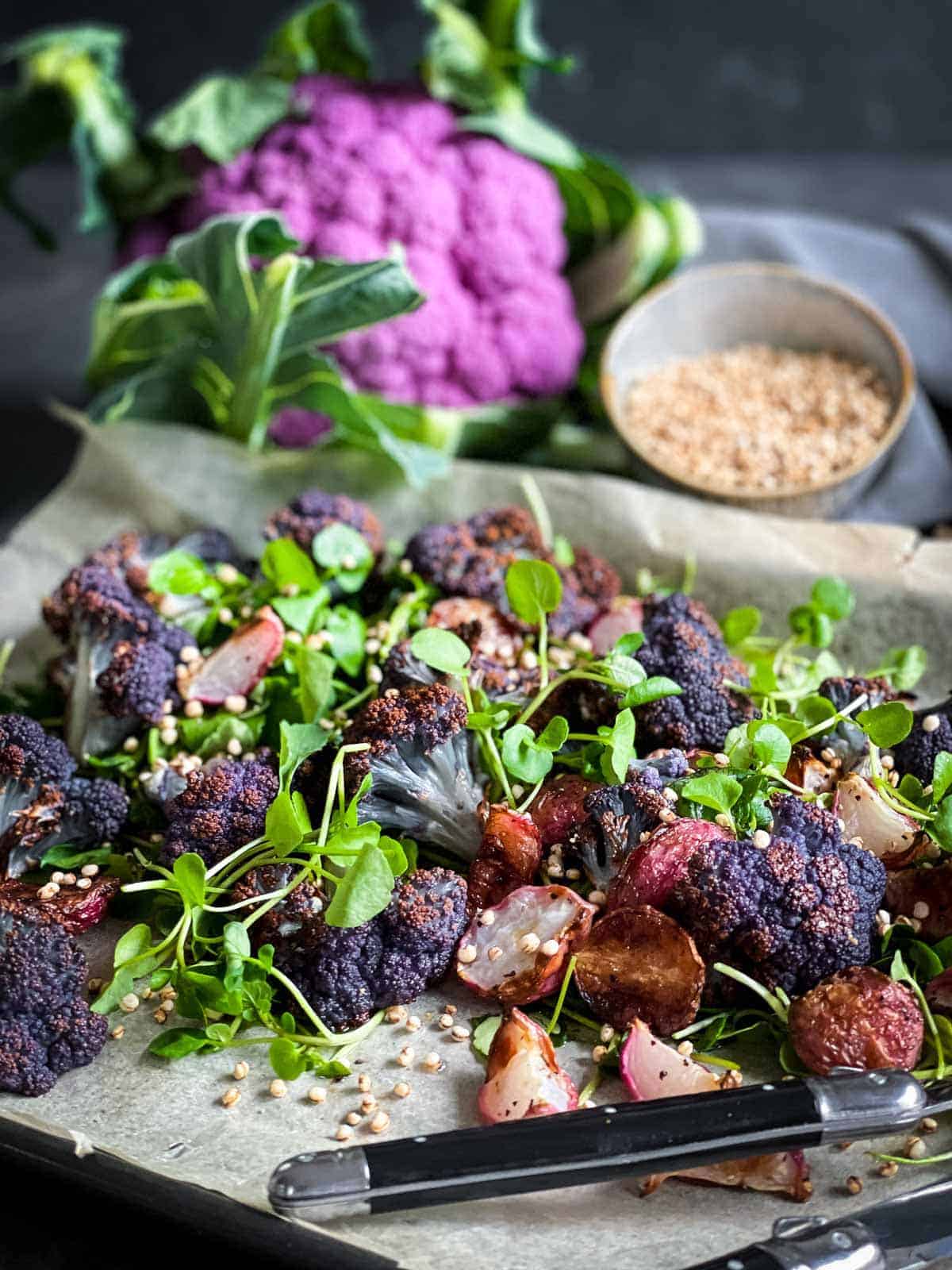 Roasted Radish Salad with purple cauliflower on a sheet pan with baking paper