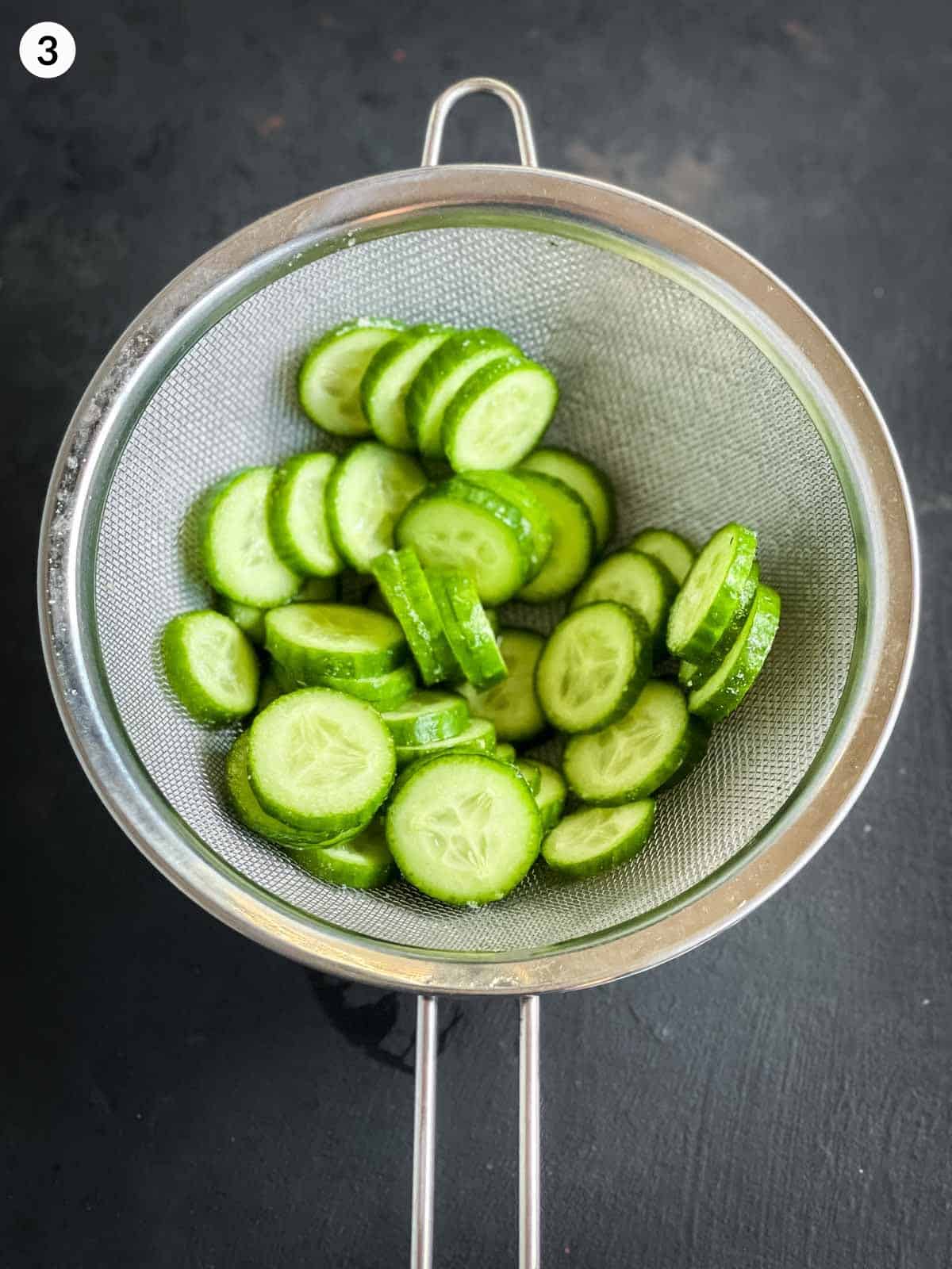 Sliced cucumber in a silver colander