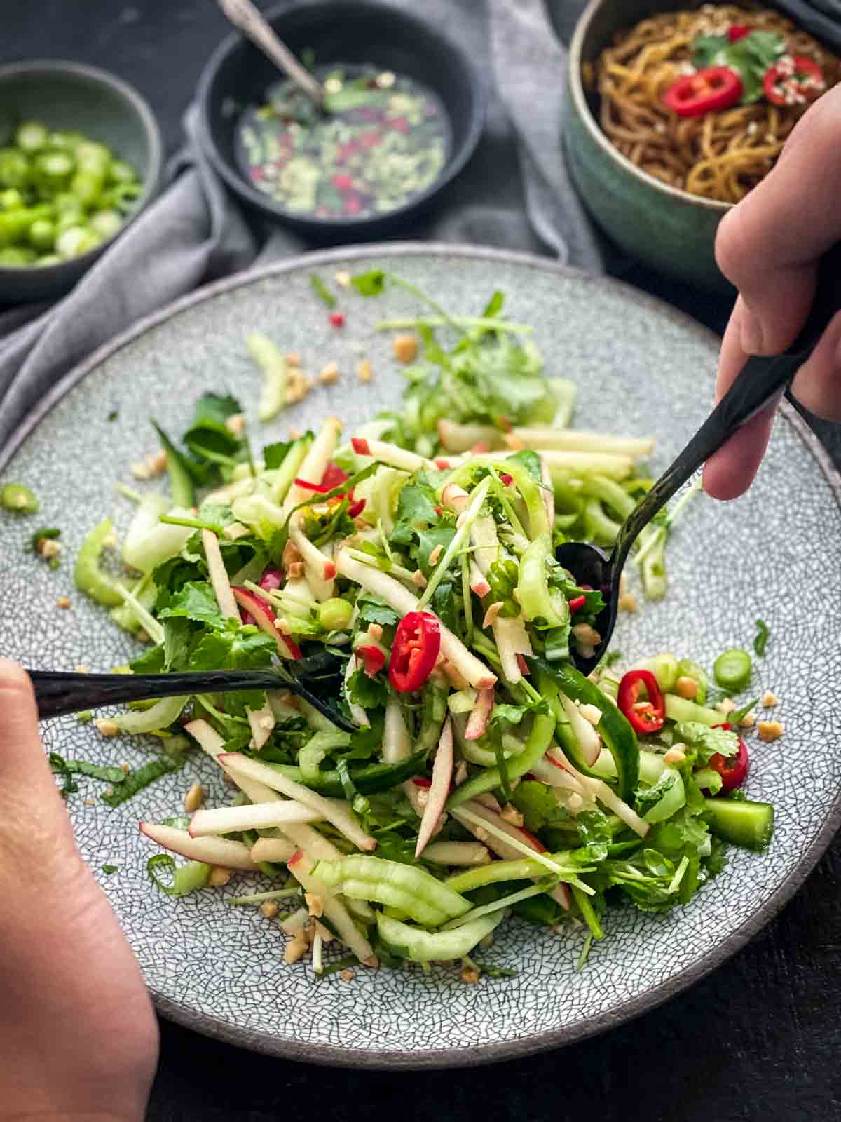 Serving Pak Choy Salad with Coriander Lime Dressing from an egg shell plate with noodles on the side.