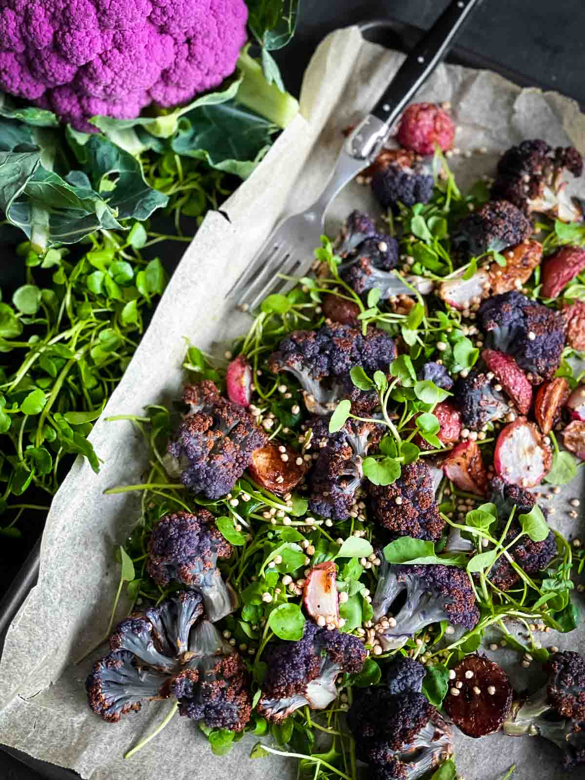 Roasted Radish Salad with Purple Cauliflower on a sheet pan with a fork