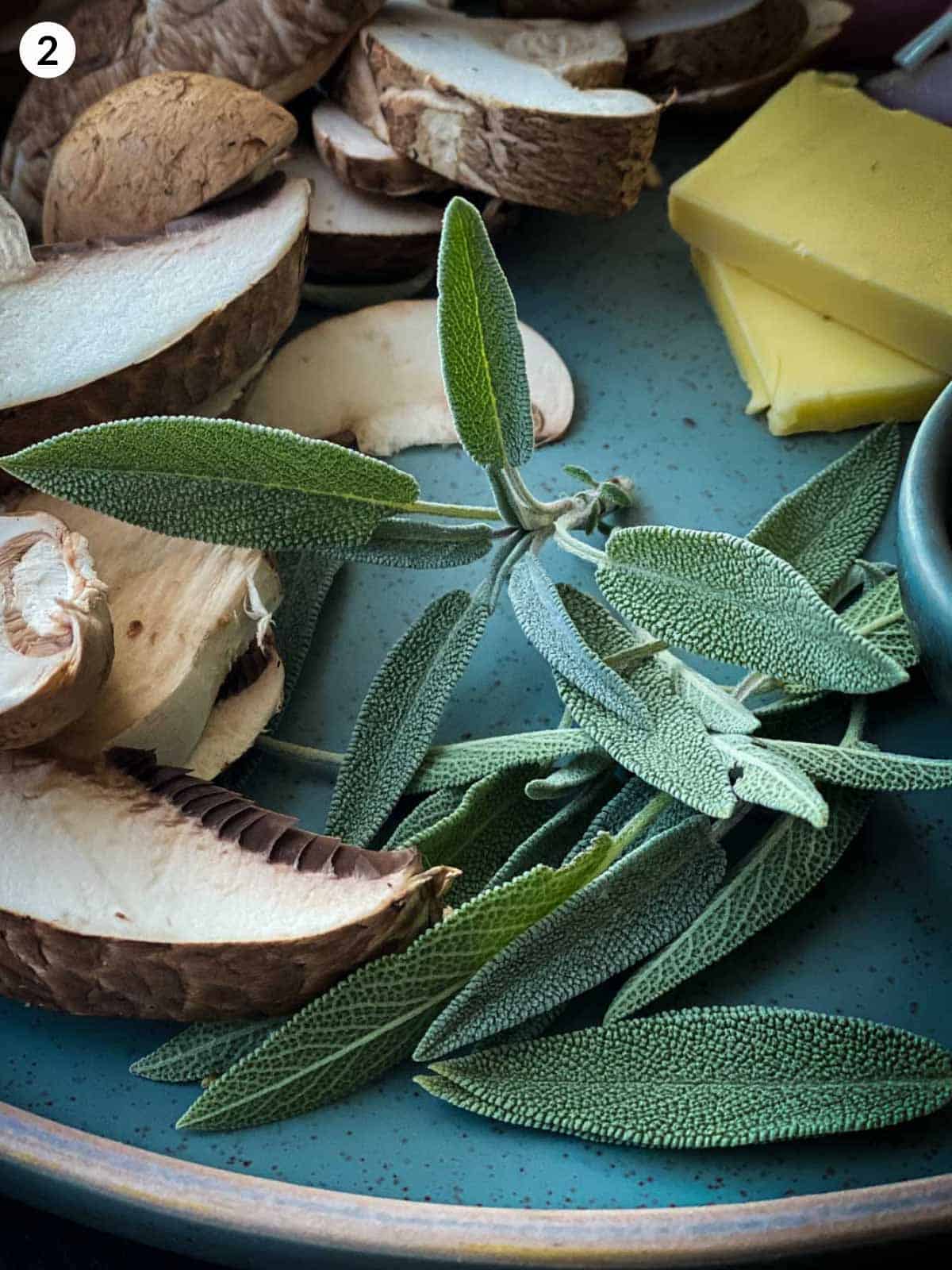 Sage leaves with sliced mushrooms and butter on a green plate