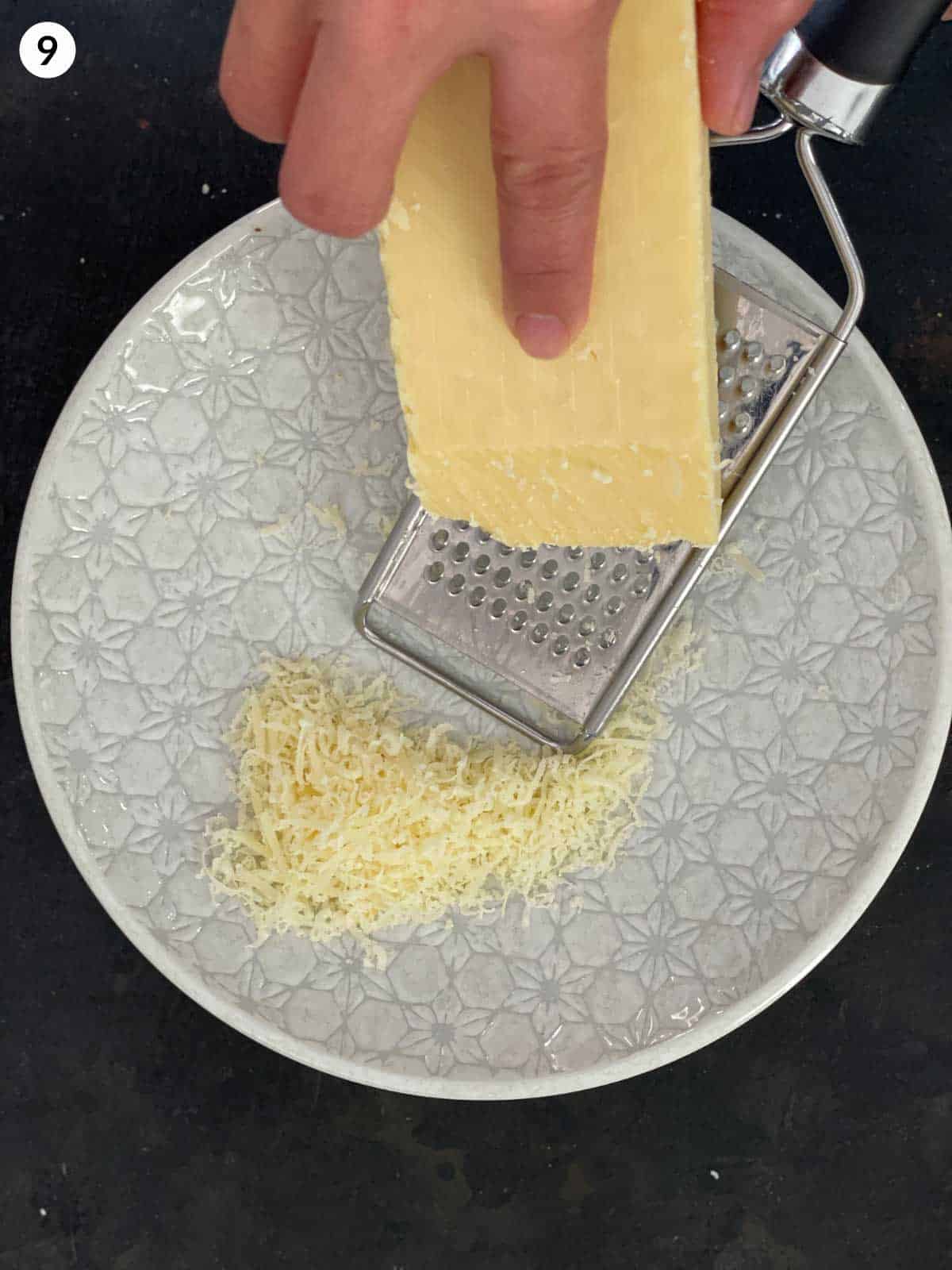 Grating parmesan cheese over a plate