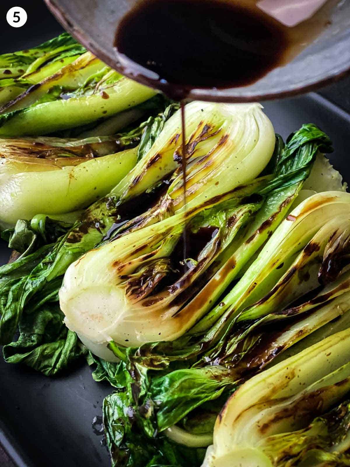 Drizzling sauce over grilled boy choy