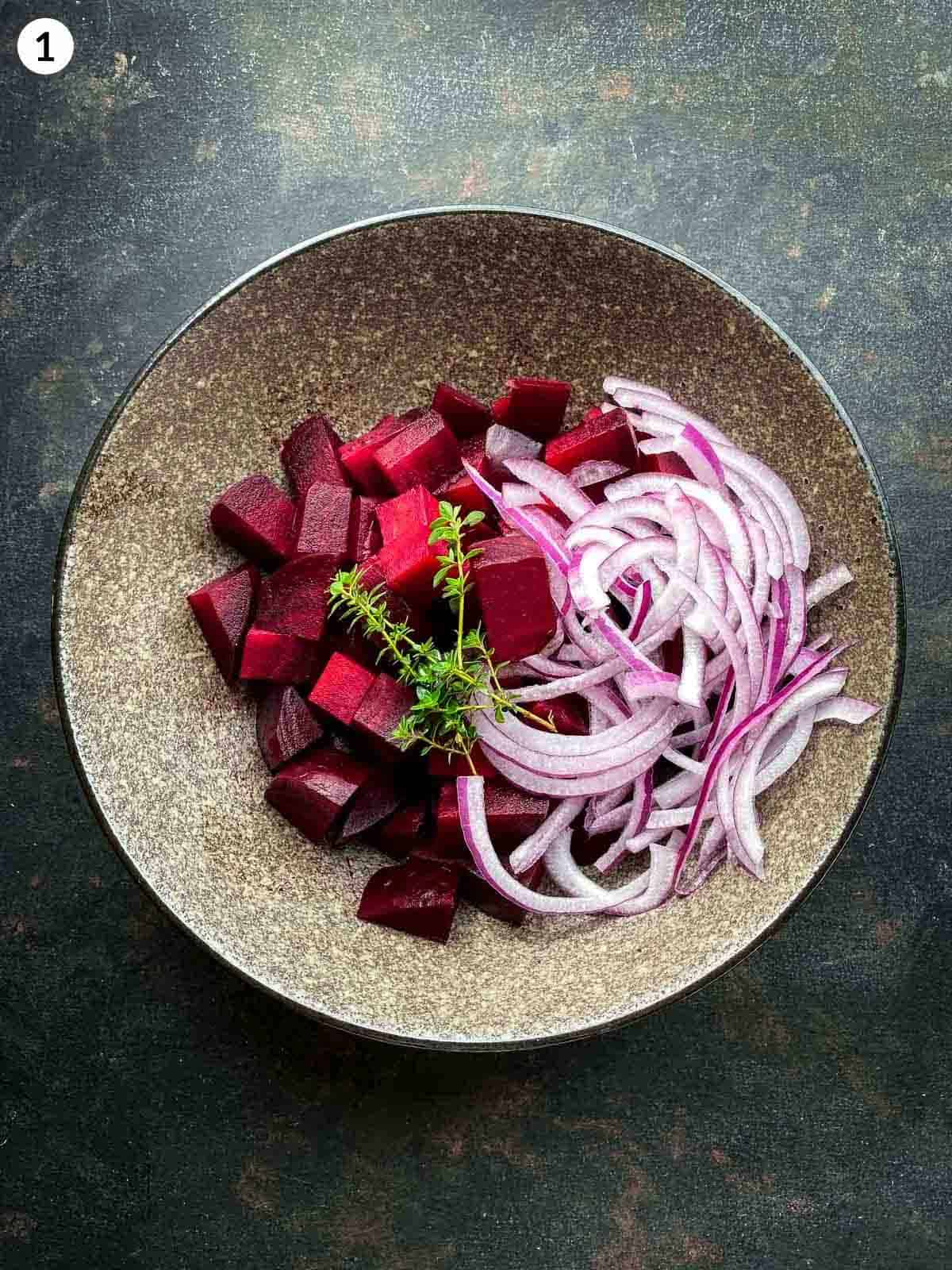 A bowl of cubed red beets and thinly sliced red onions