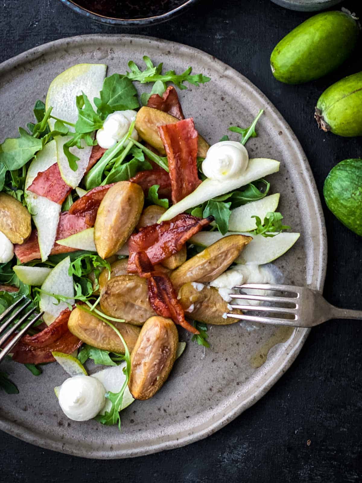 Roasted Feijoa Salad on a grey earthen plate with 2 forks