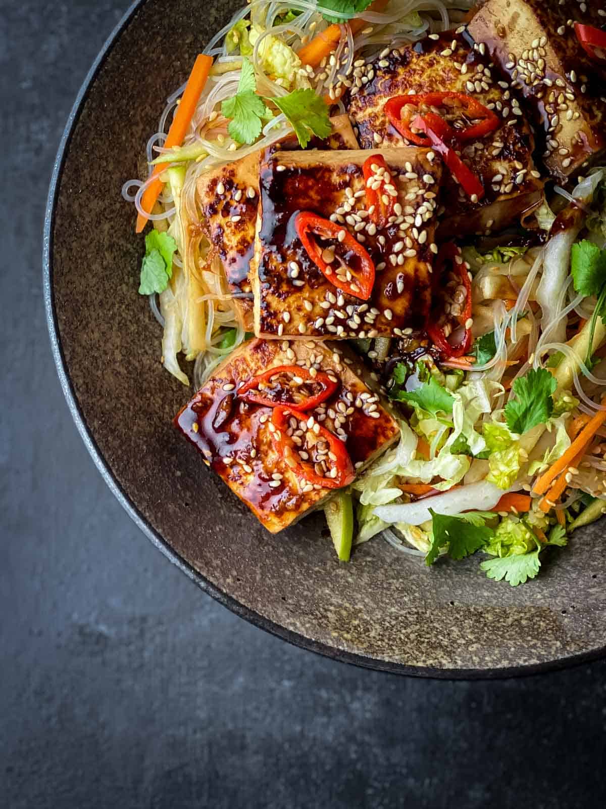Close up image of Glass Noodle Salad with Sticky Tofu in a brown bowl