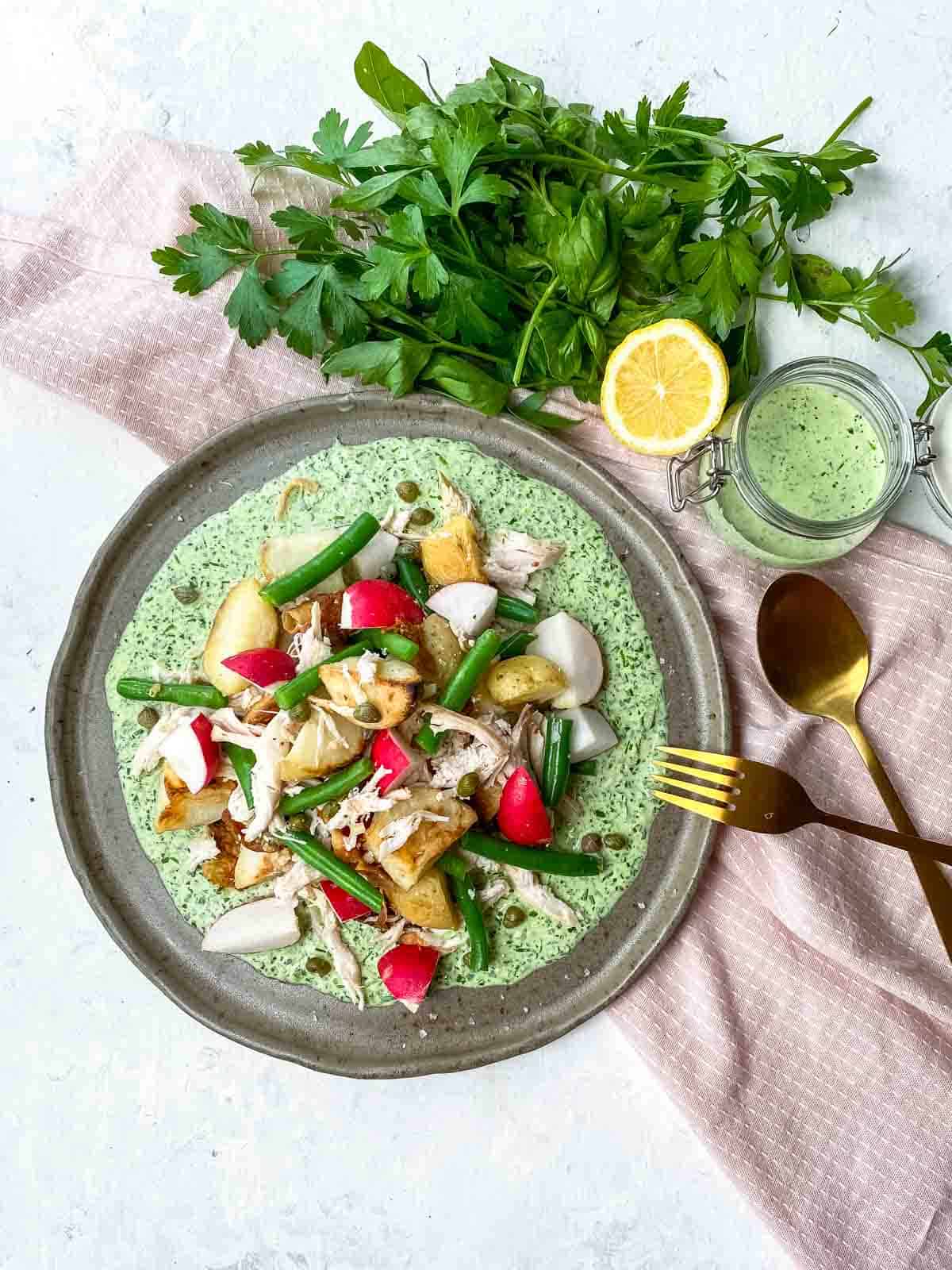 Leftover Roast Chicken Potato Salad with a gold fork and a jar of healthy green goddess dressing