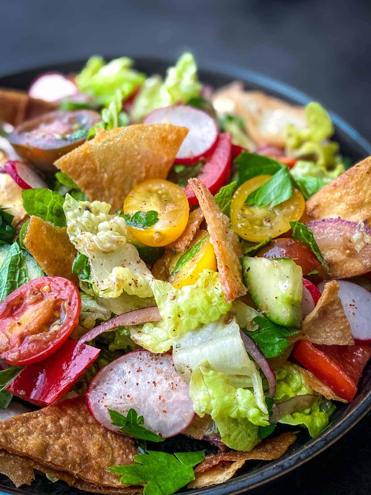 fattoush salad in a round black bowl