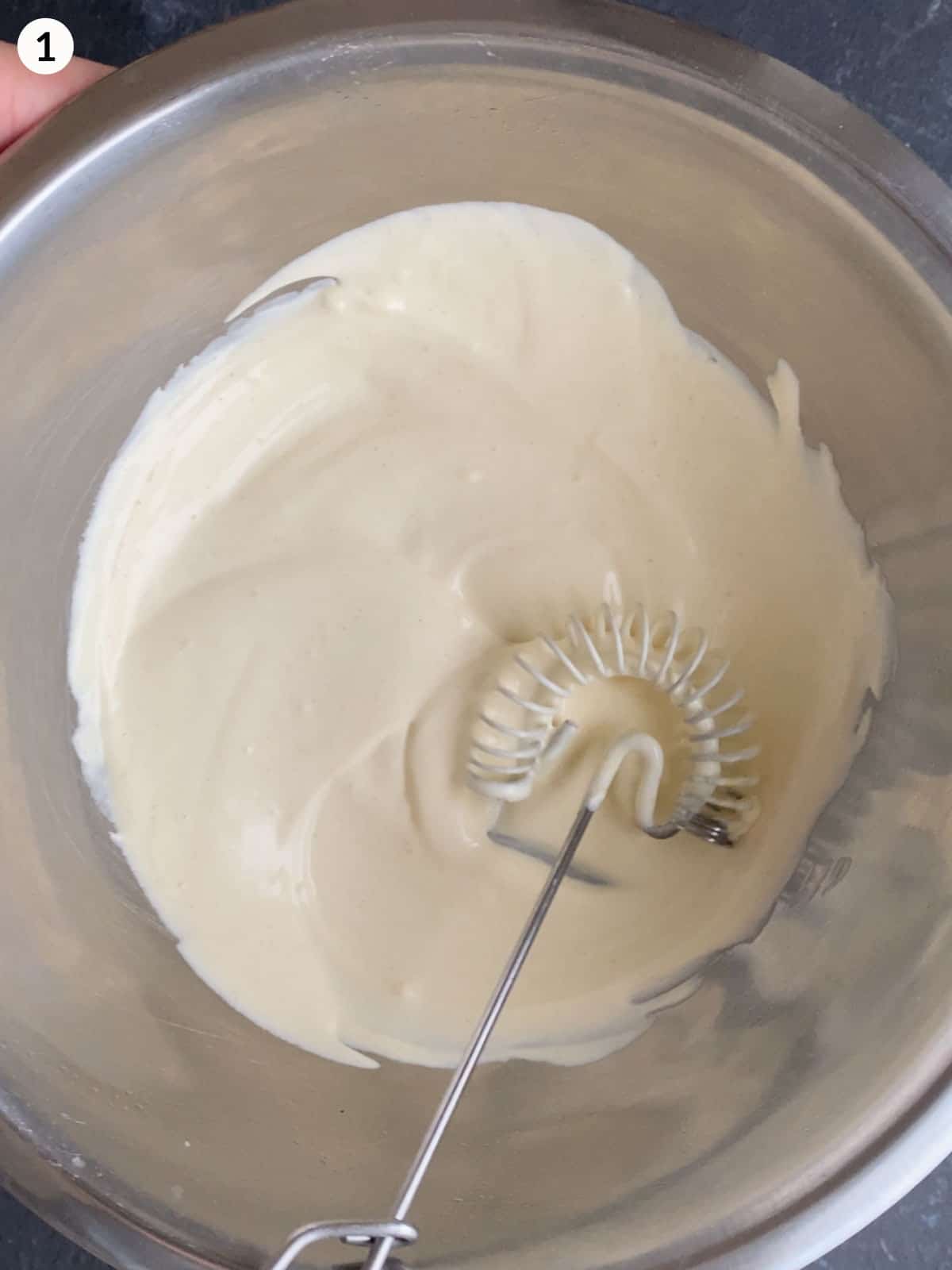 Mixing mayonnaise dressing with a whisk in a stainless steel mixing bowl