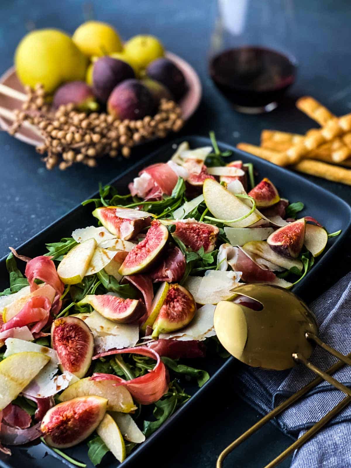 Fig and Prosciutto Salad with Nashi Pear on a rectangular platter served with breadsticks