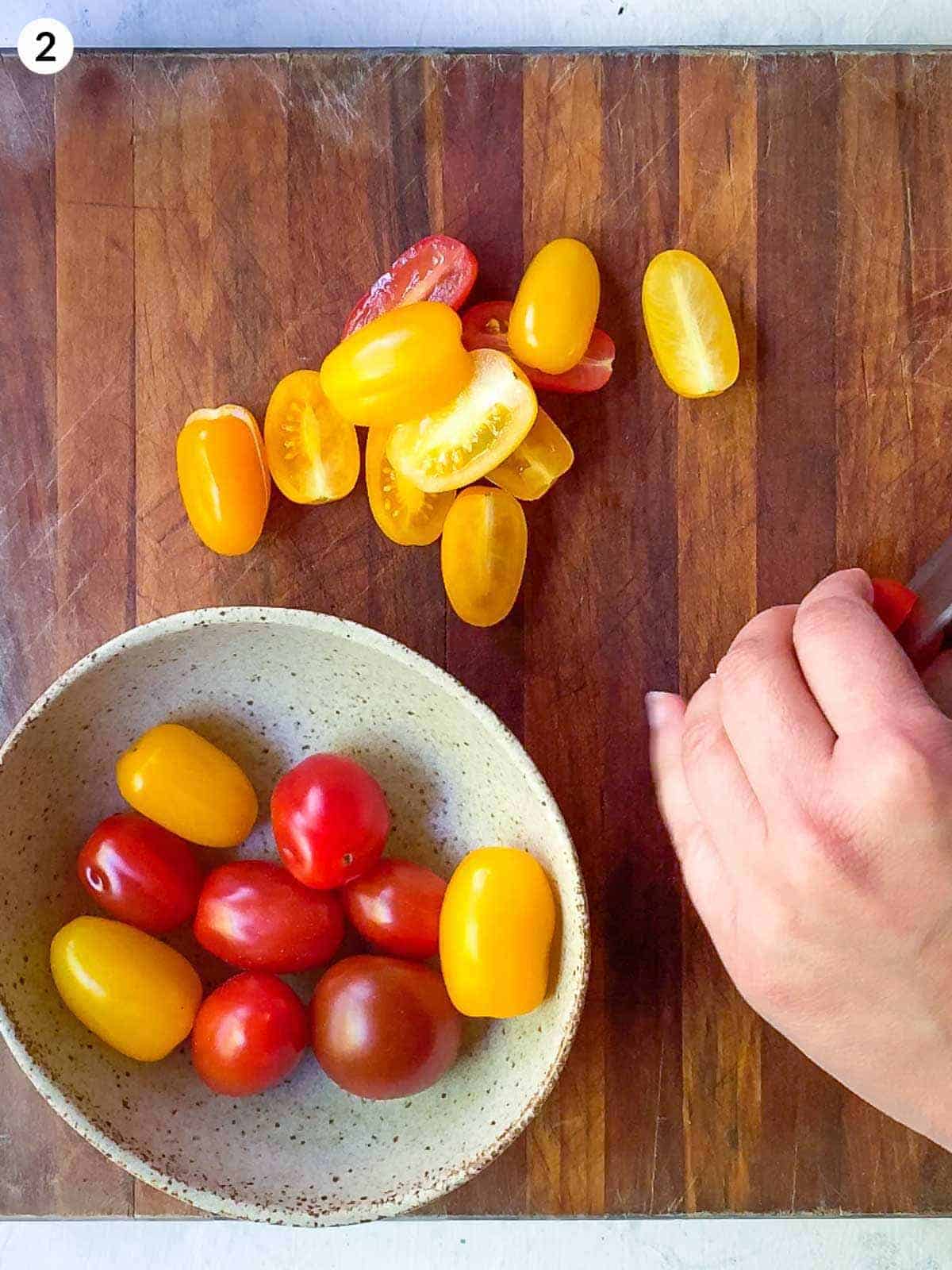 slicing cherry tomatoes on a wooden chopping board