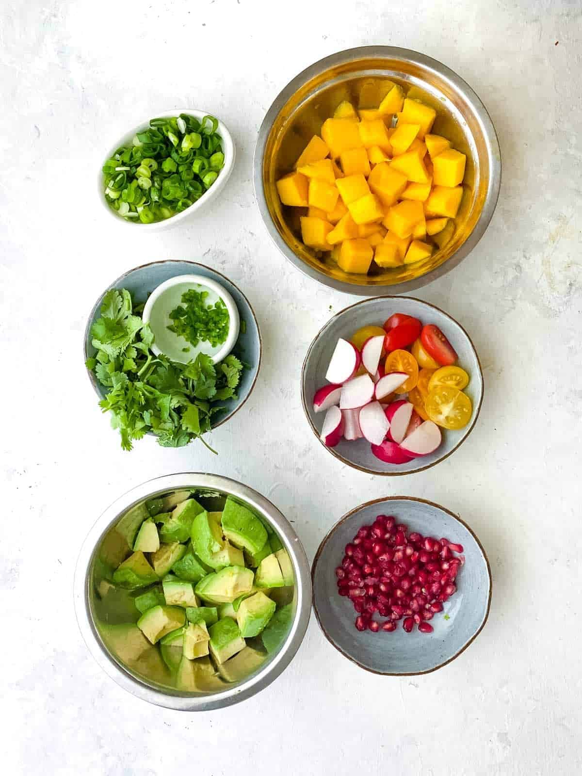 Several ingredients in individual bowls to make Spicy Mango Avocado Salsa