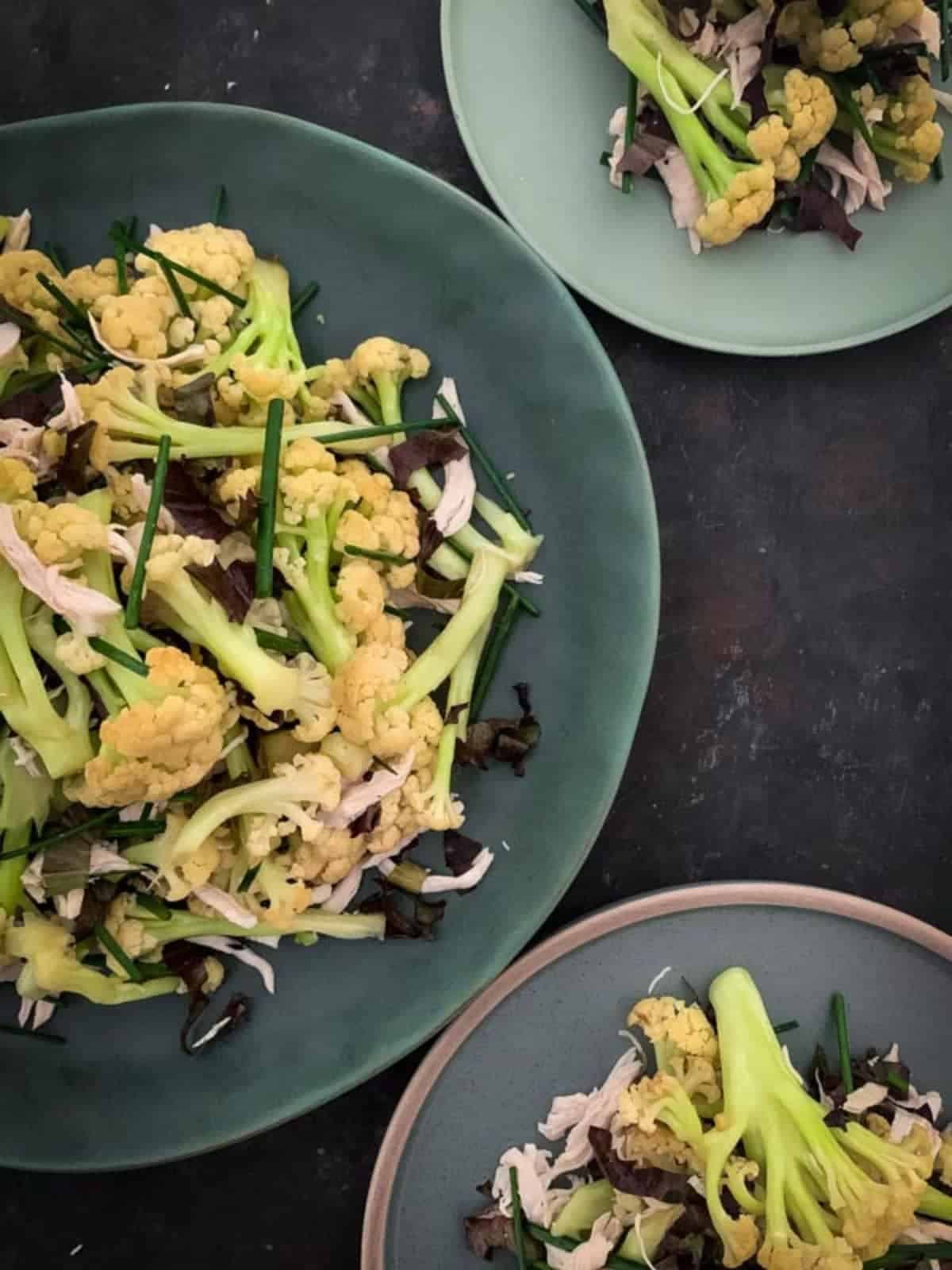 3 serves of Chinese cauliflowers and chicken salad on a variety of green plates