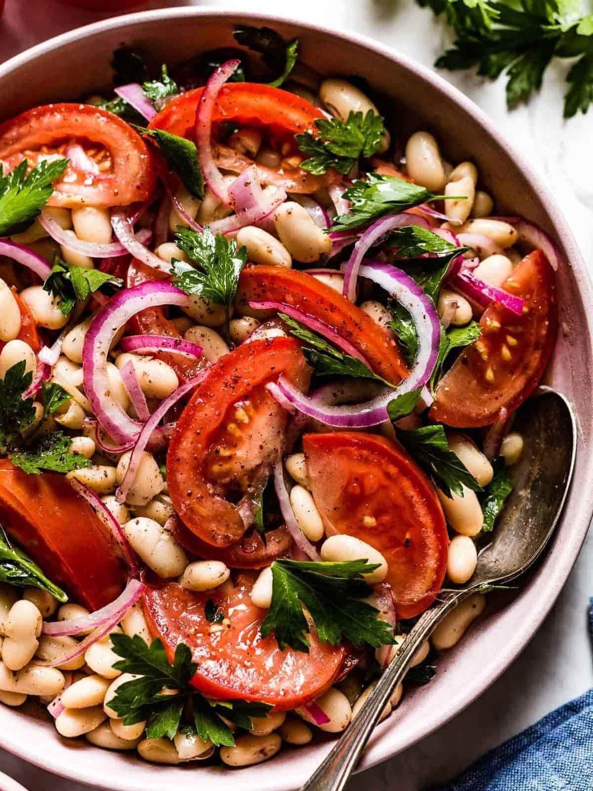 Turkish Navy Bean salad in a pink bowl wit a spoon