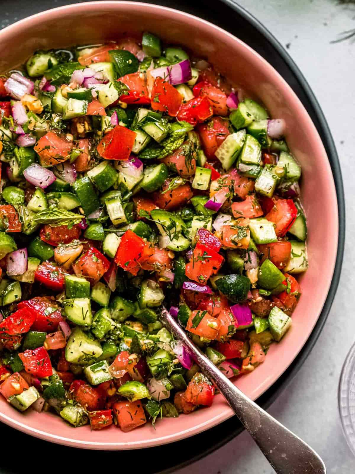 Shirazi Persian salad in a pink bowl with a spoon