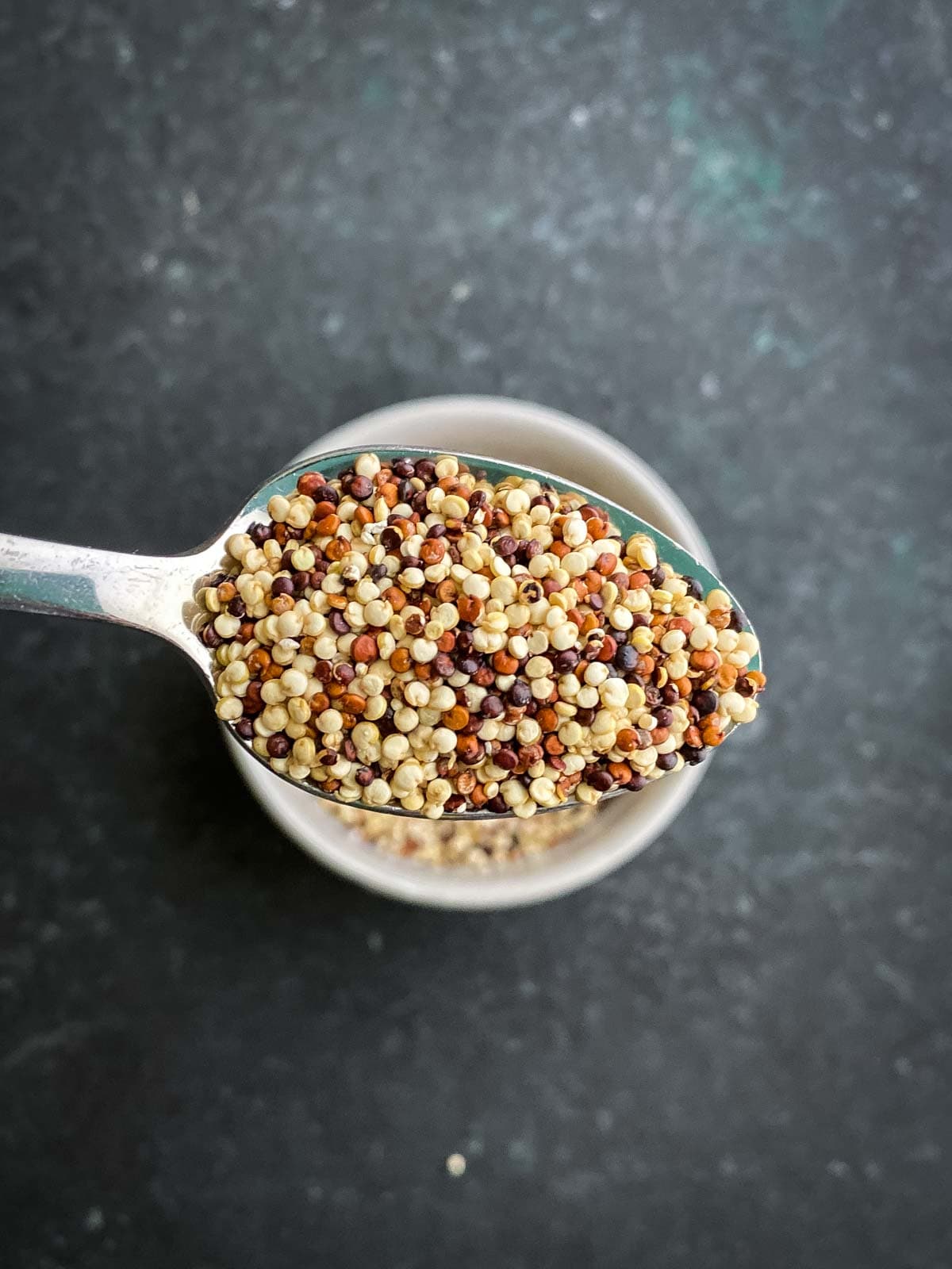 a spoonful of uncooked tricolour quinoa