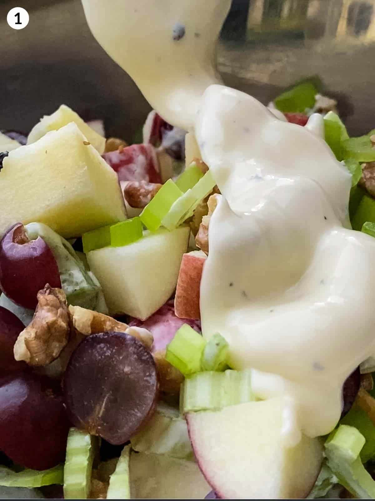 pouring mayonnaise dressing in a bowl with Waldorf salad ingredients