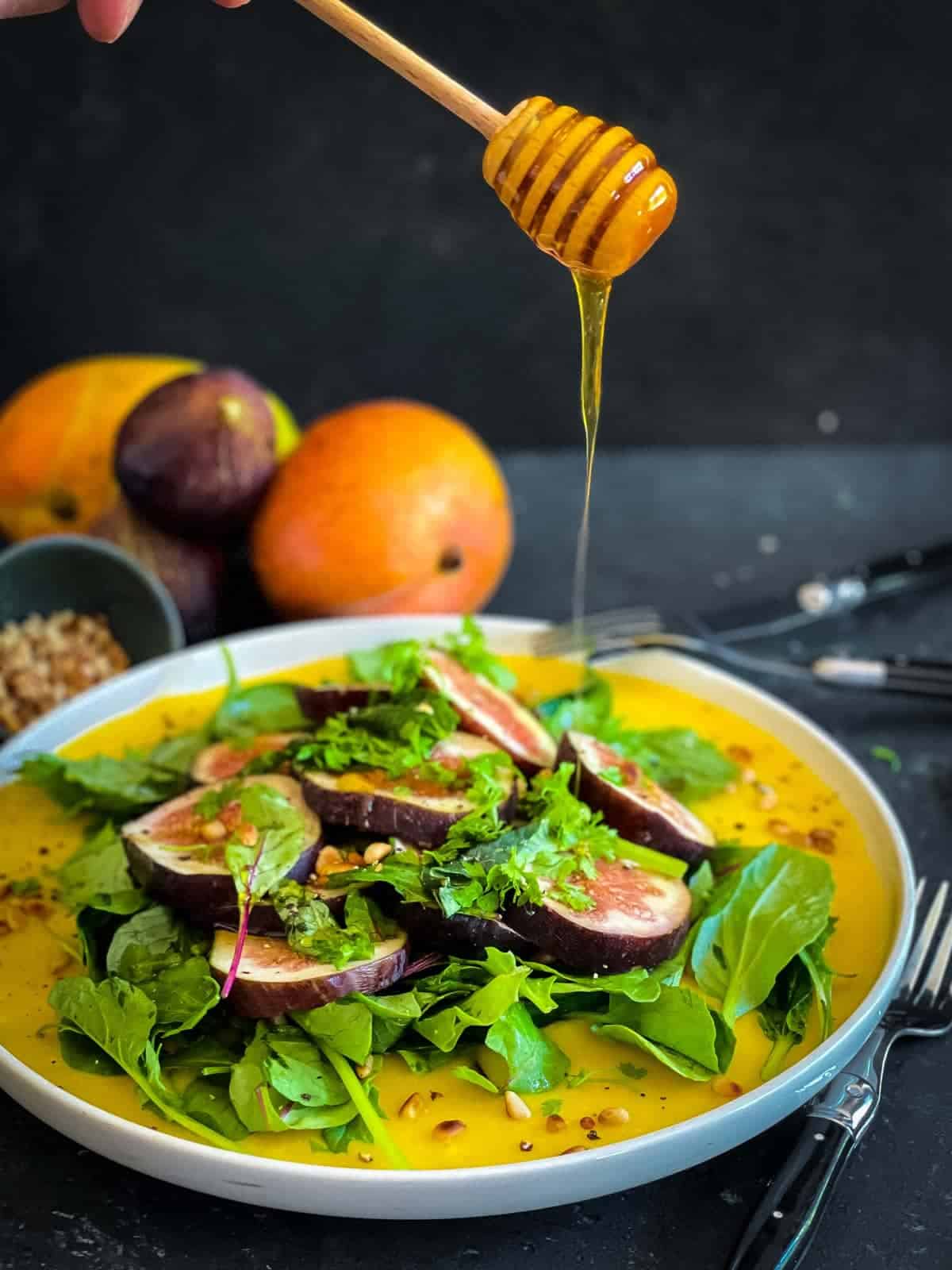 Drizzling honey over Fresh Fig Salad Recipe With Mango