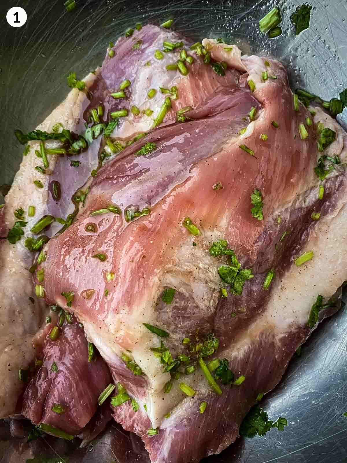 Grilled pork marinating in a glass bowl