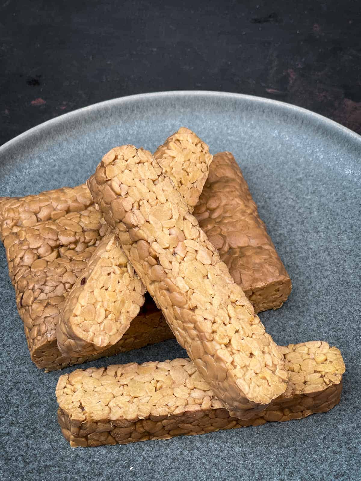 slices of tempeh on a grey plate