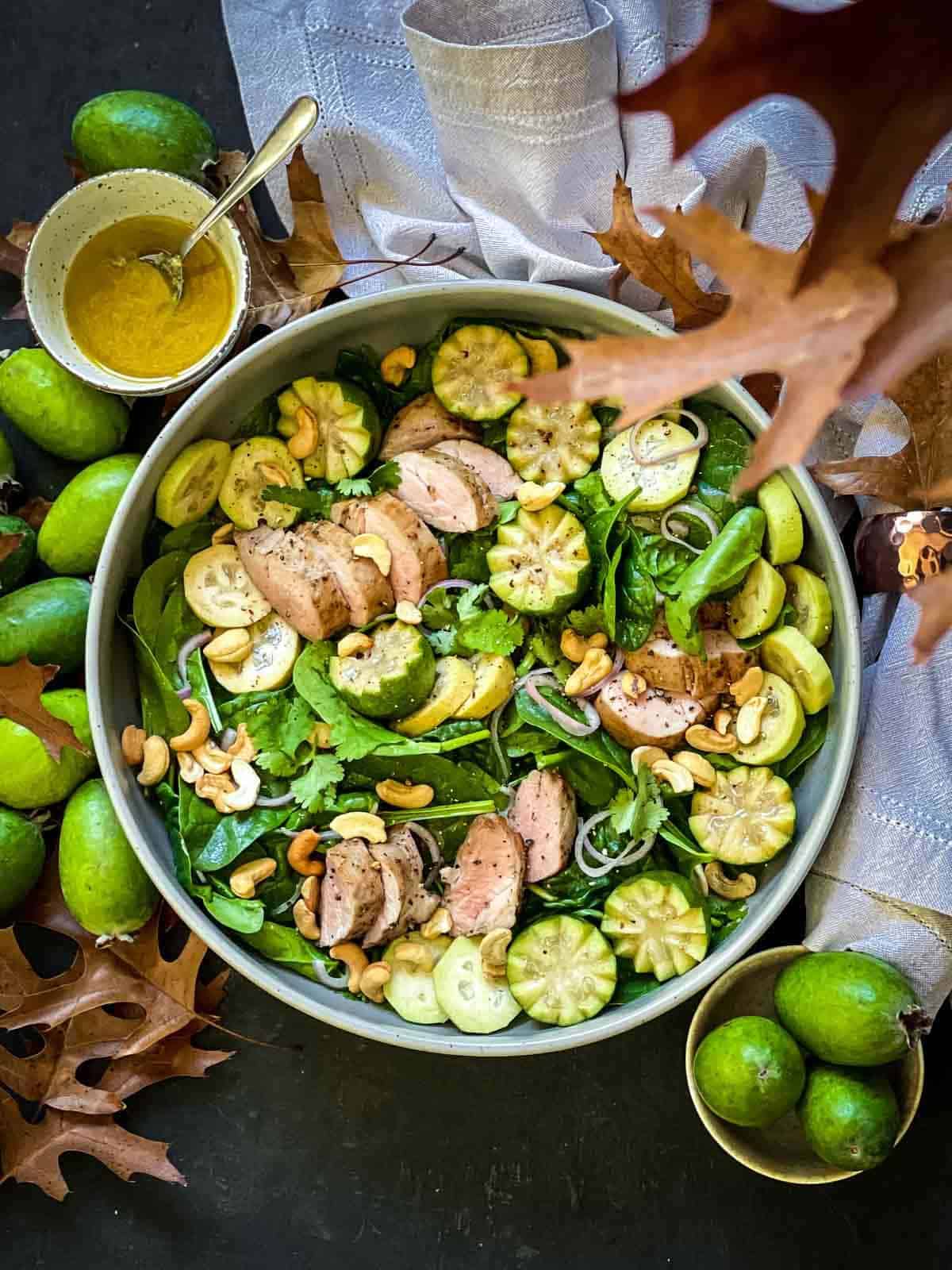 Sous Vide Pork Tenderloin Salad surrounded by fresh feijoas and fall leaves