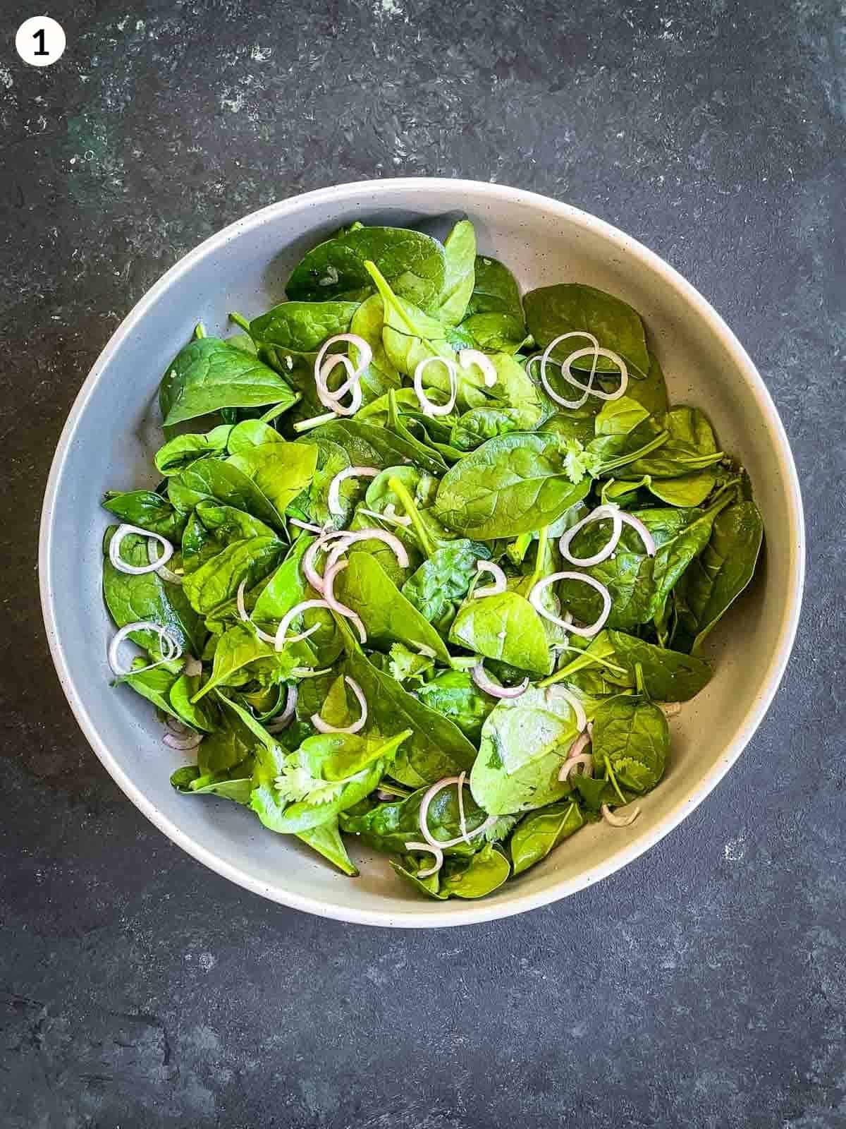 baby spinach leaves and shallots in a round bowl