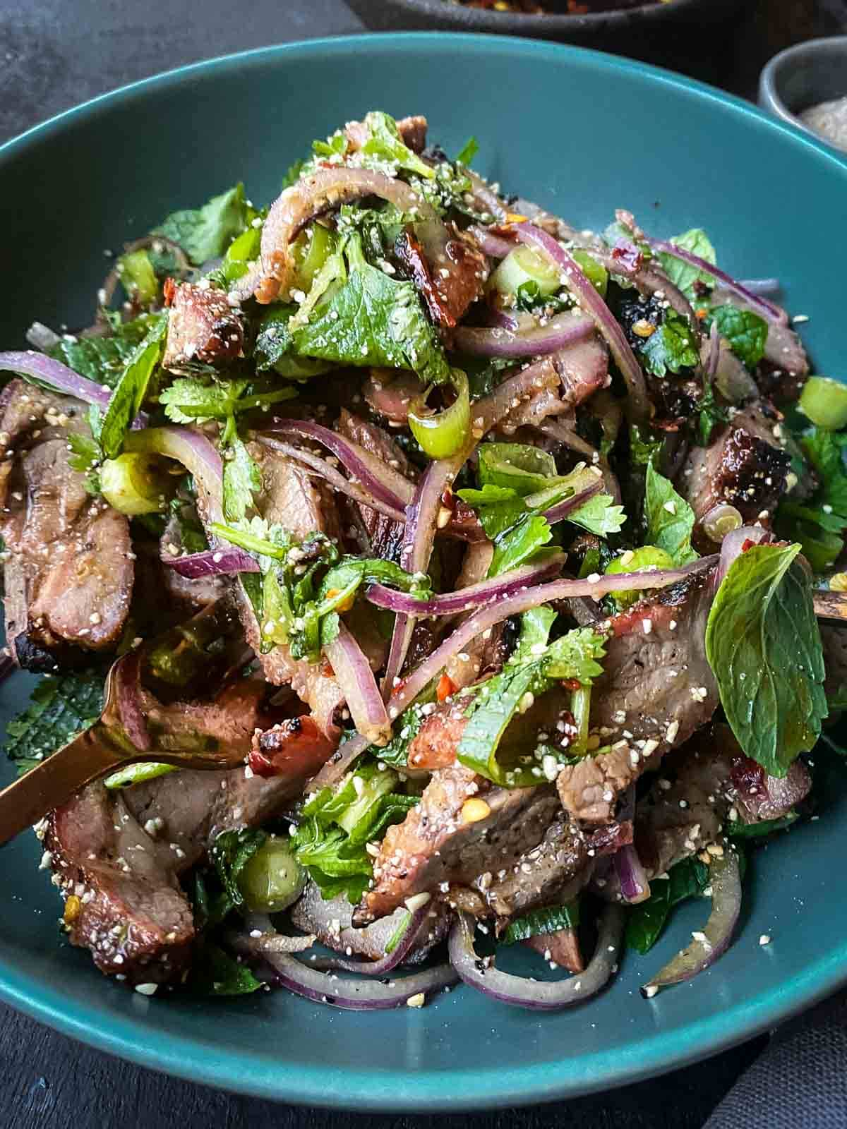 Thai Grilled Pork Salad in a bright blue bowl