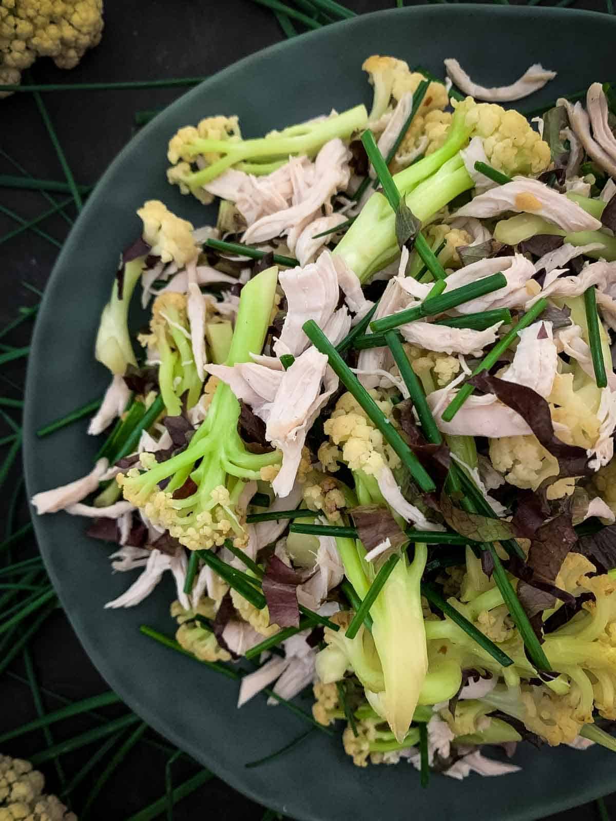 Chinese Cauliflower Salad with Shredded Chicken on a green plate