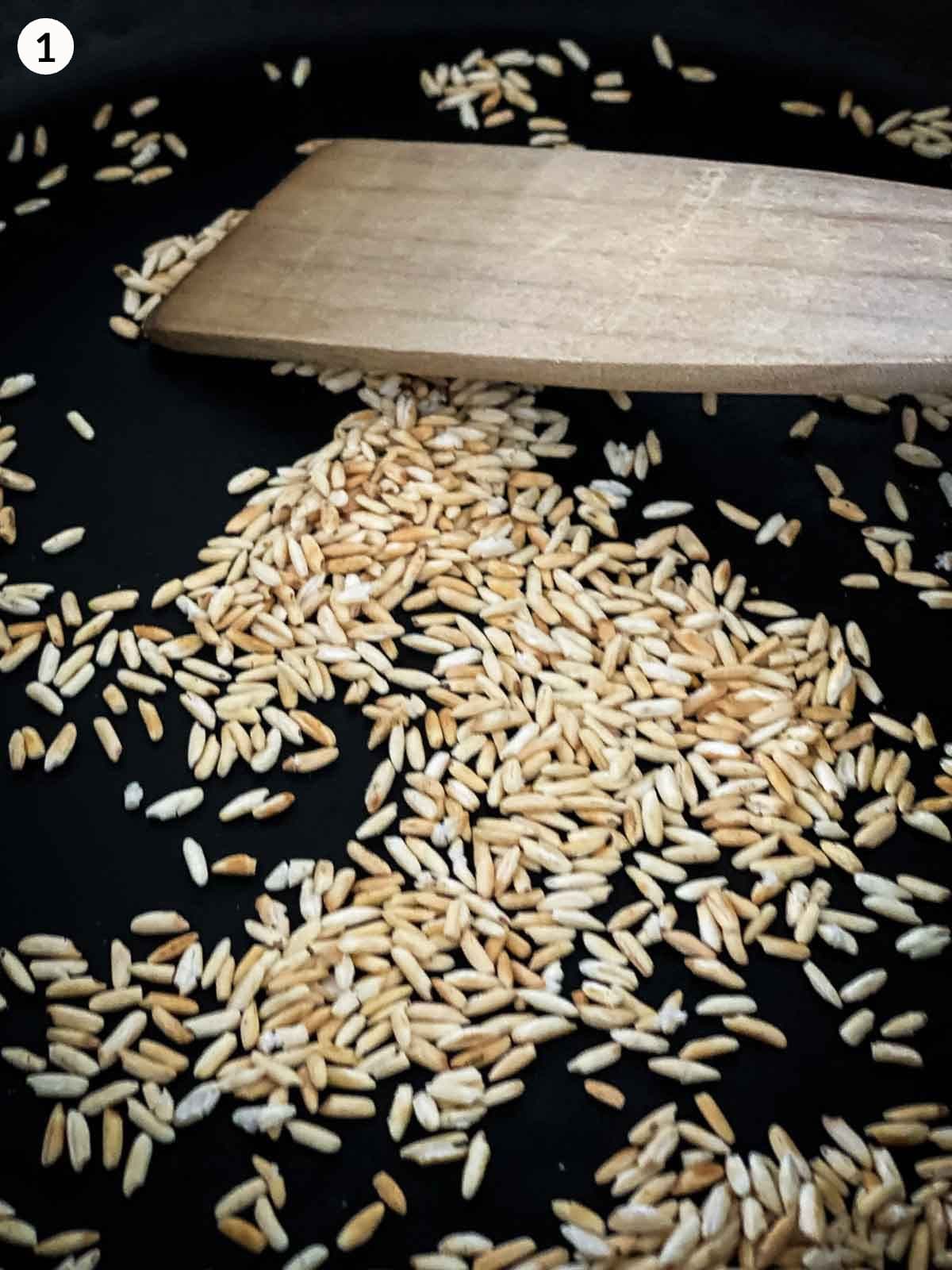 glutinous rice dry toasting on a fry pan with wooden spatula stirring