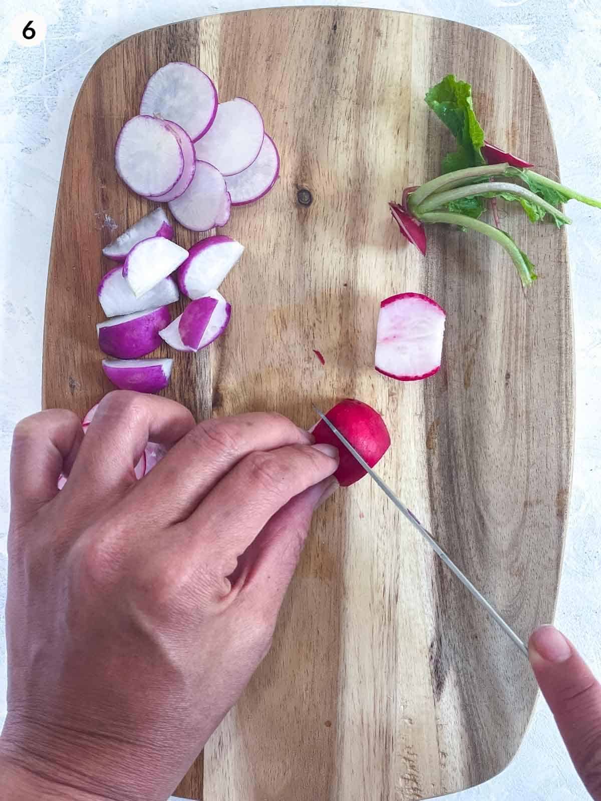 cutting radishes with a knife on a wooden board