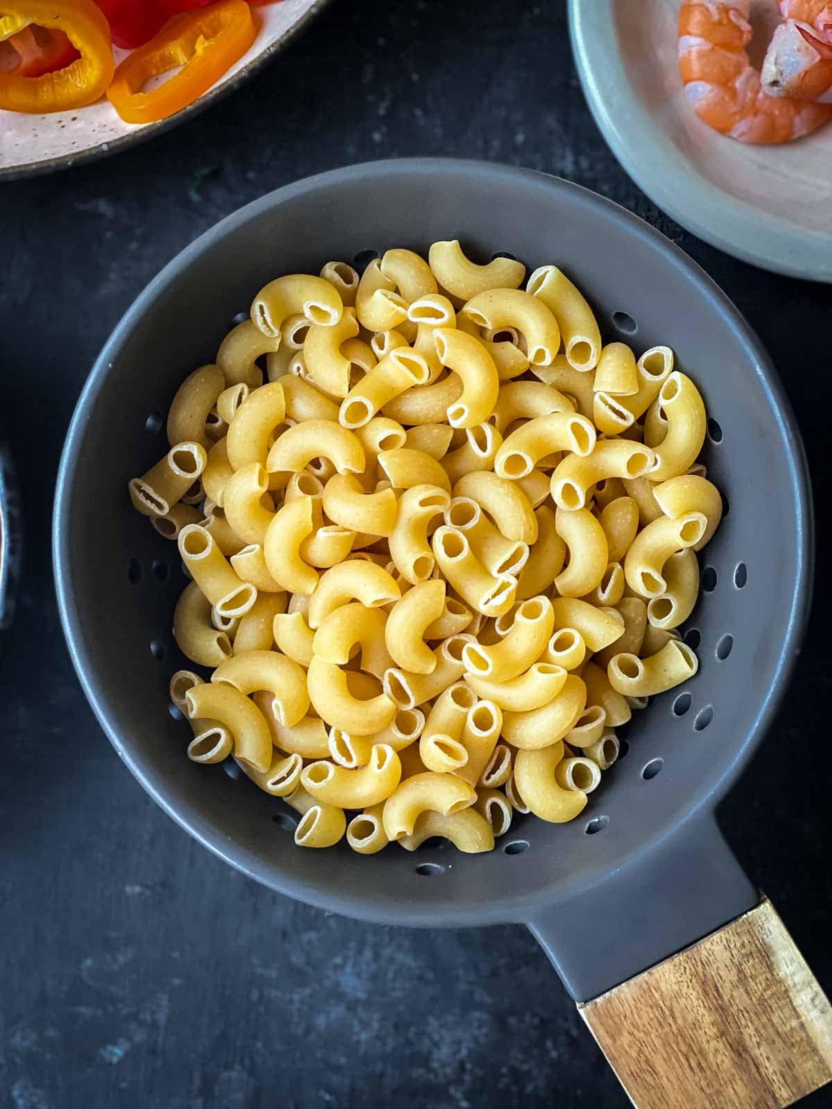 uncooked macaroni in a black bowl