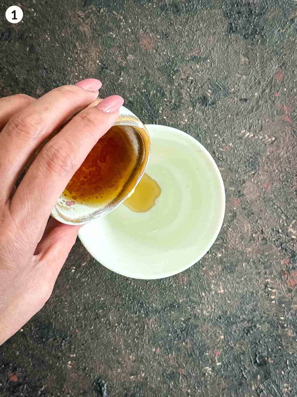 Adding fish sauce into a white bowl