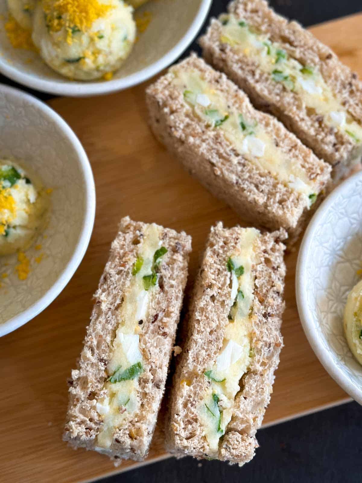 Korean potato salad finger sandwiches on a wooden board