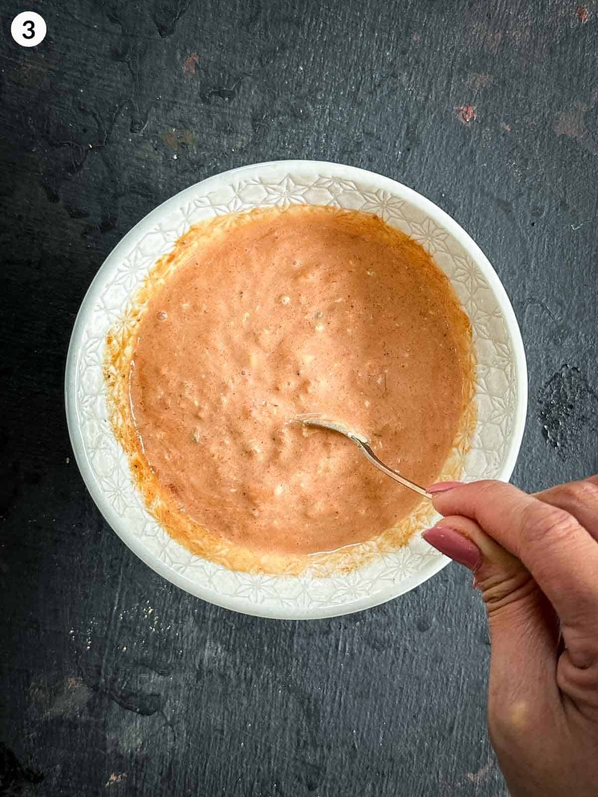 Mixing a bowl of ingredients for salas salad dressing