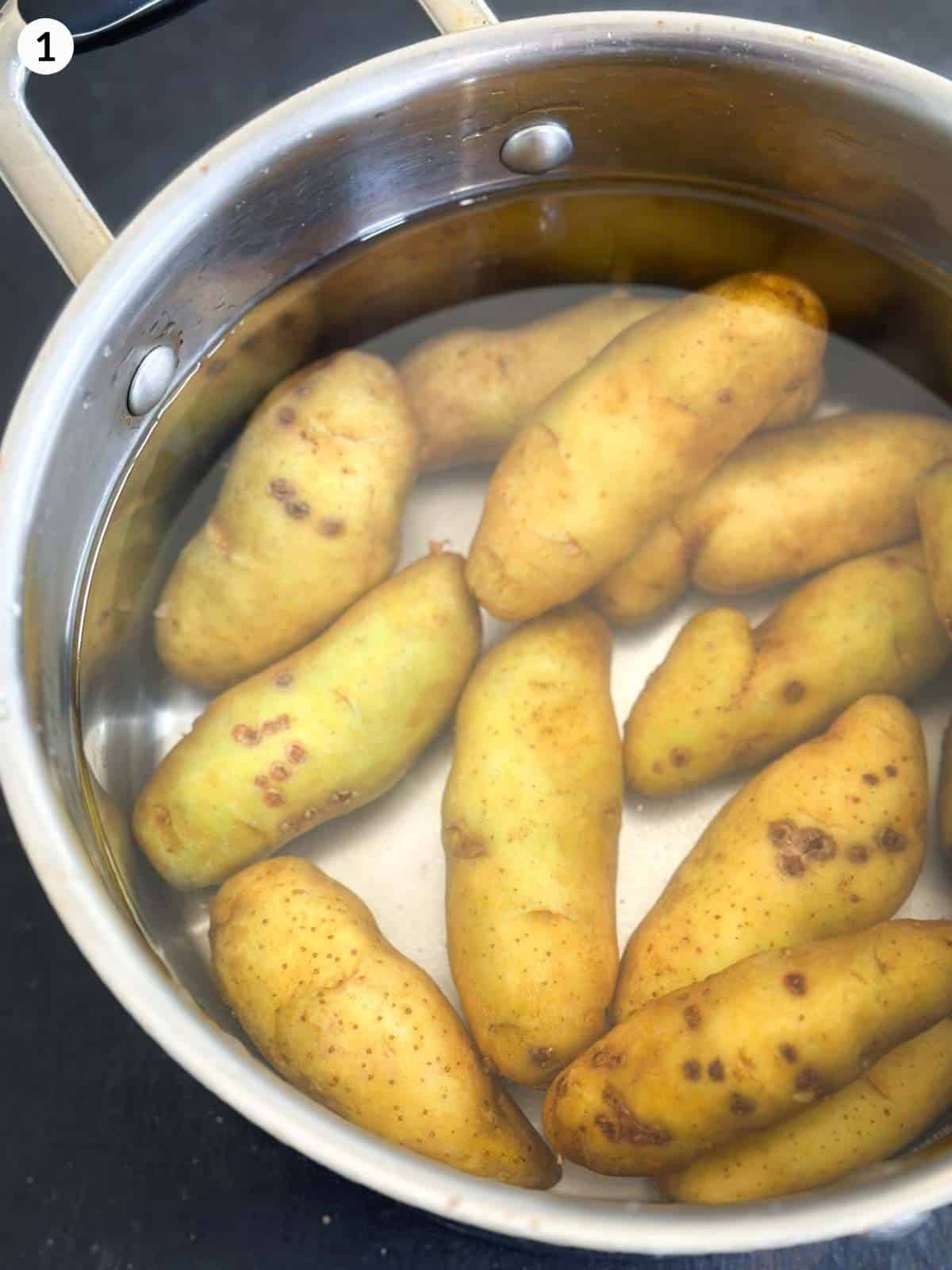 Adding fingerling potatoes into a pot of water