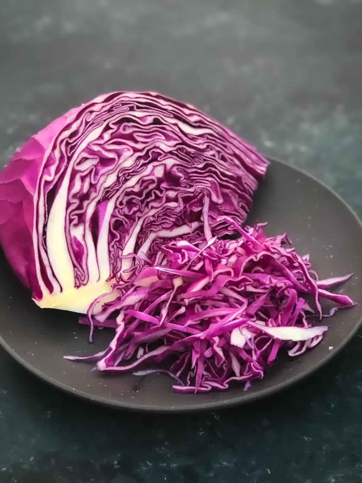 Wedges of red cabbage and sliced cabbage on a brown plate