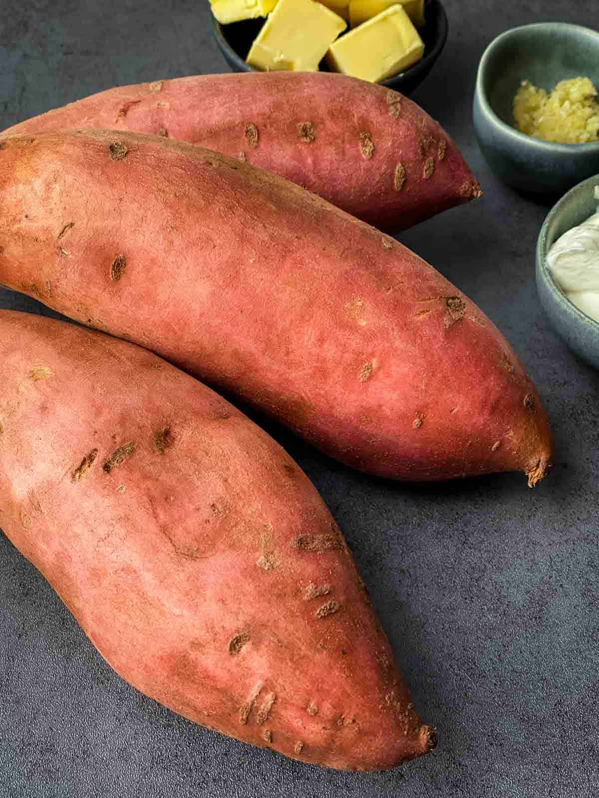 3 whole sweet potato with butter and garlic on the side