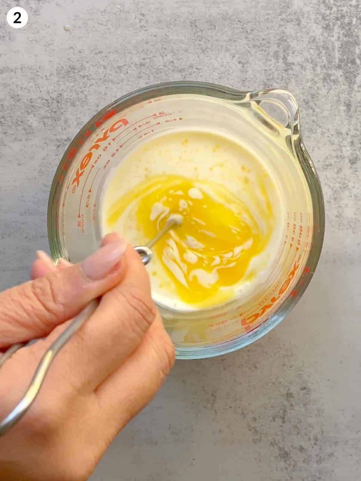 Whisking cream, milk and melted butter in a measuring cup