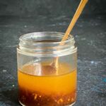 Small jar if Ginger Salad Dressing with Tamarind with a teaspoon inside