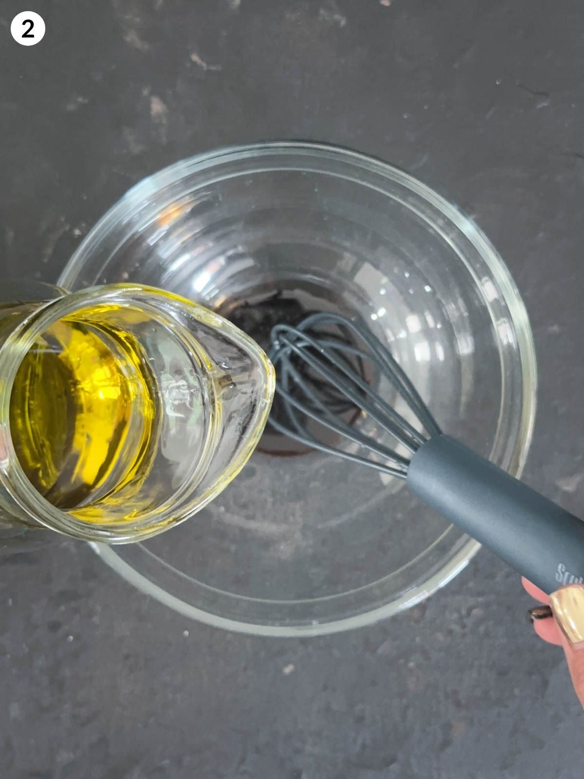 Adding olive oil into a clear mixing bowl