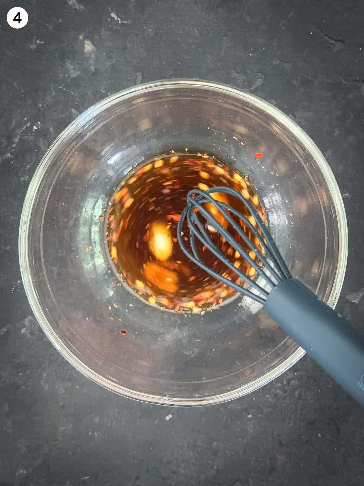 Mixing ingredients for chilli soy dressing in a clear mixing bowl