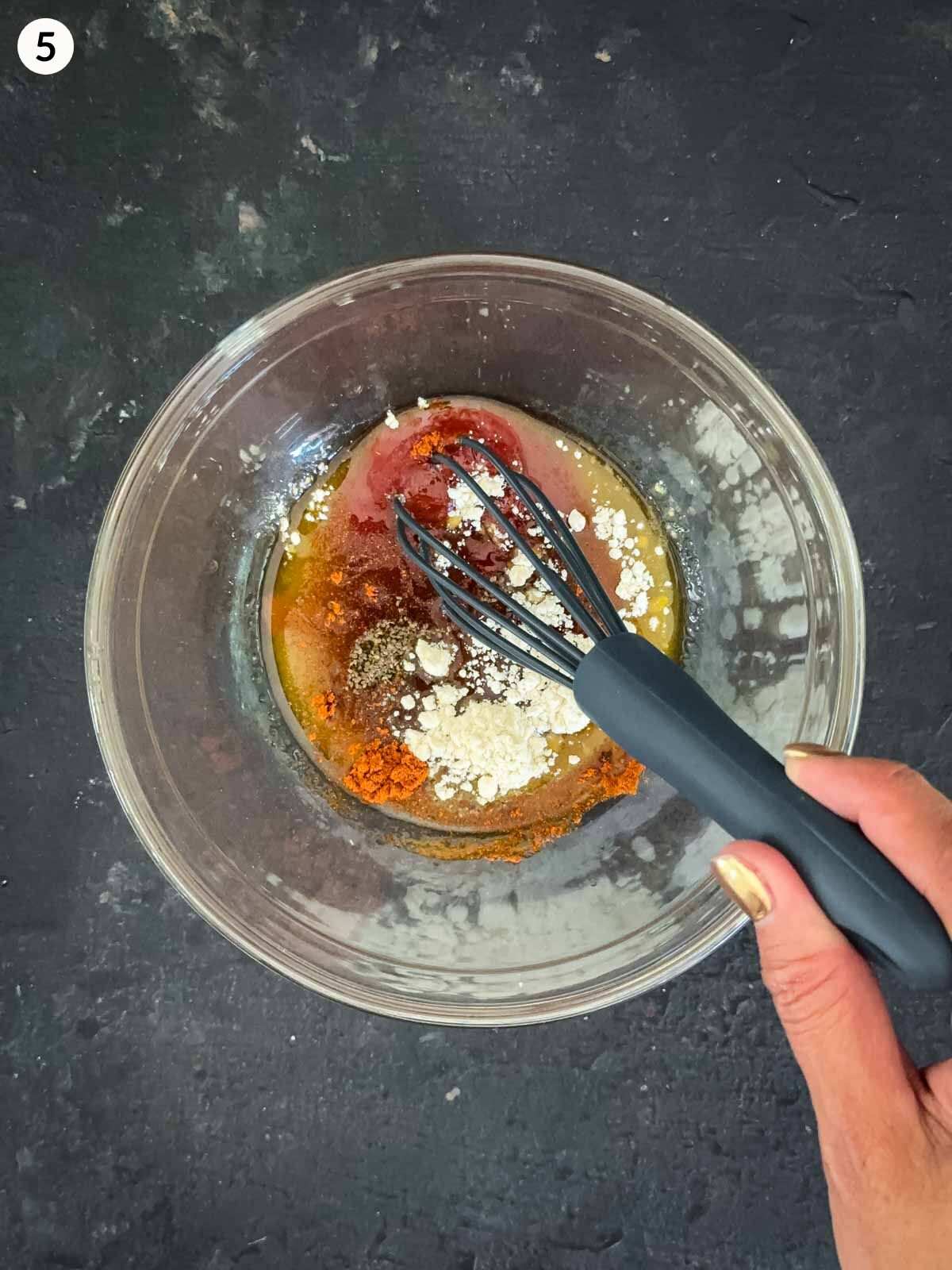 Mixing Catalina dressing ingredients together with a whisk, in a small clear mixing bowl