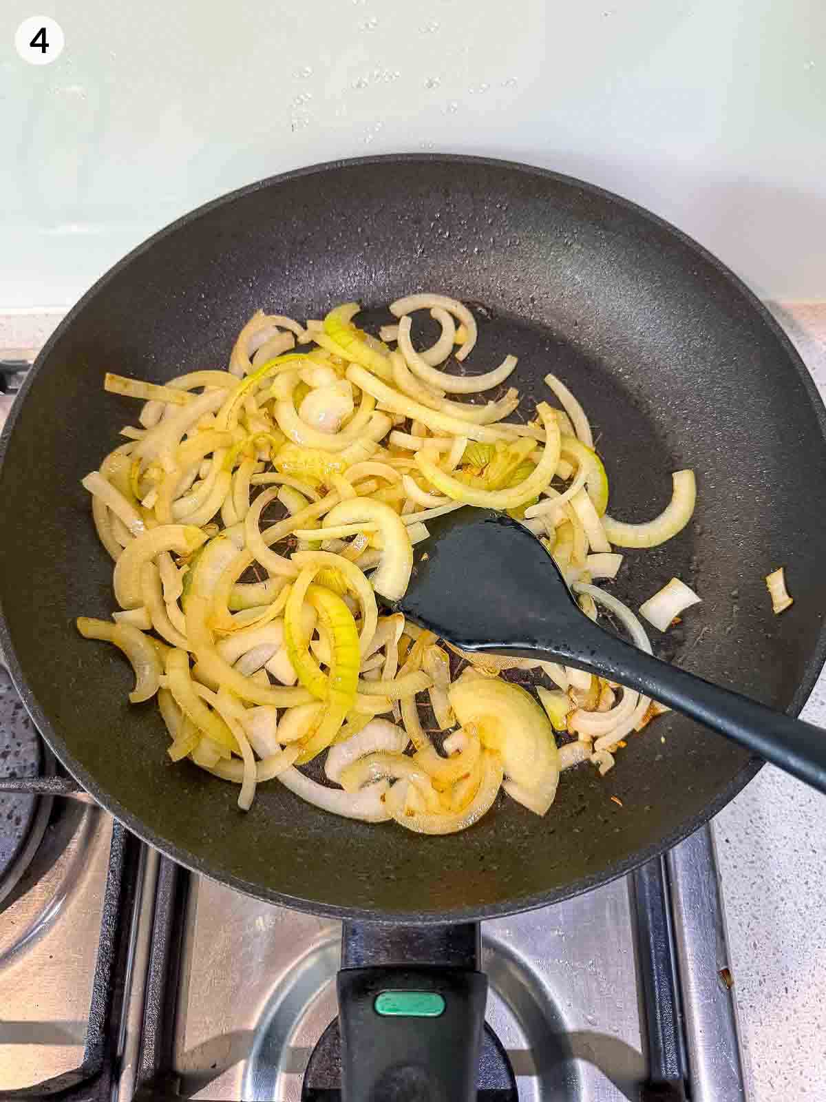 Sliced onions sautéing in a frying pan — step for roasted cauliflower salad with sweet and savoury Greek yoghurt dressing.